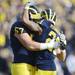 Michigan wide receiver Roy Roundtree hugs teammate offensive linesman Elliott Mealer during the second quarter at Michigan Stadium. Melanie Maxwell I AnnArbor.com